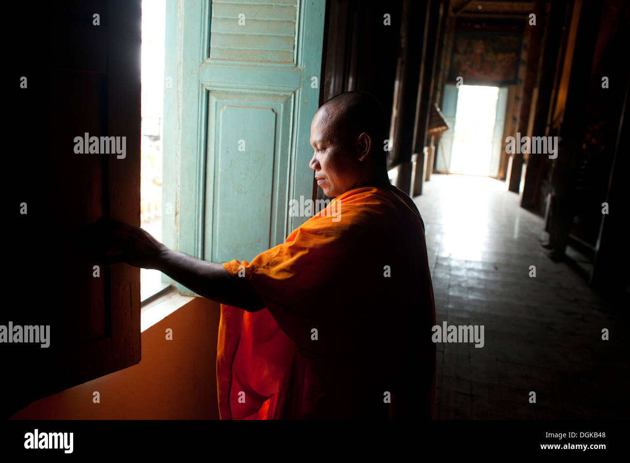 Un monaco si chiude una finestra in un piccolo villaggio fuori del tempio di Phnom Penh Cambogia. Foto © Dennis Drenner 2013. Foto Stock