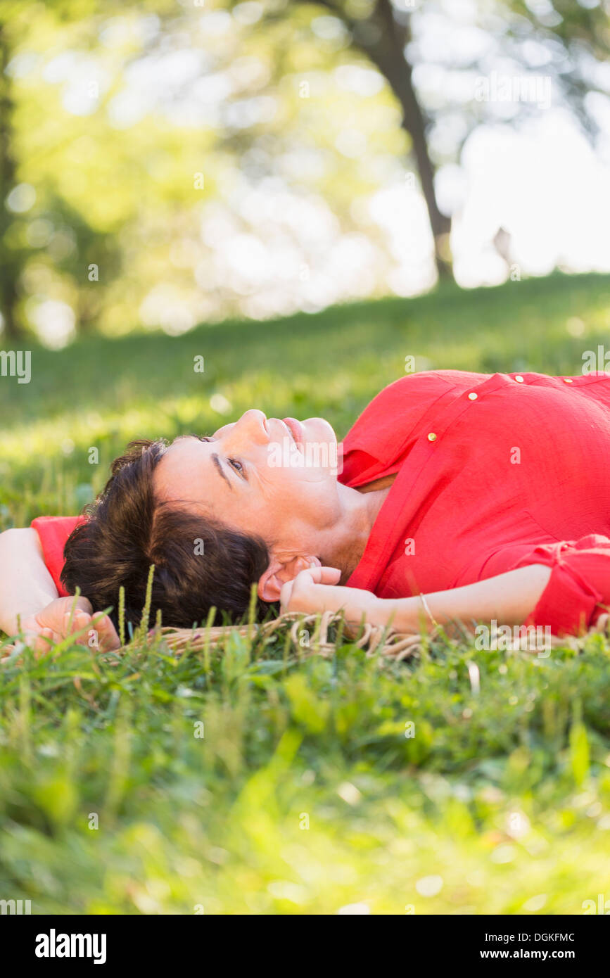 Donna matura sdraiati sull'erba Foto Stock