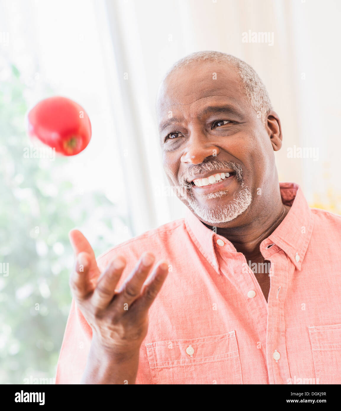 Ritratto di uomo gettando red apple Foto Stock