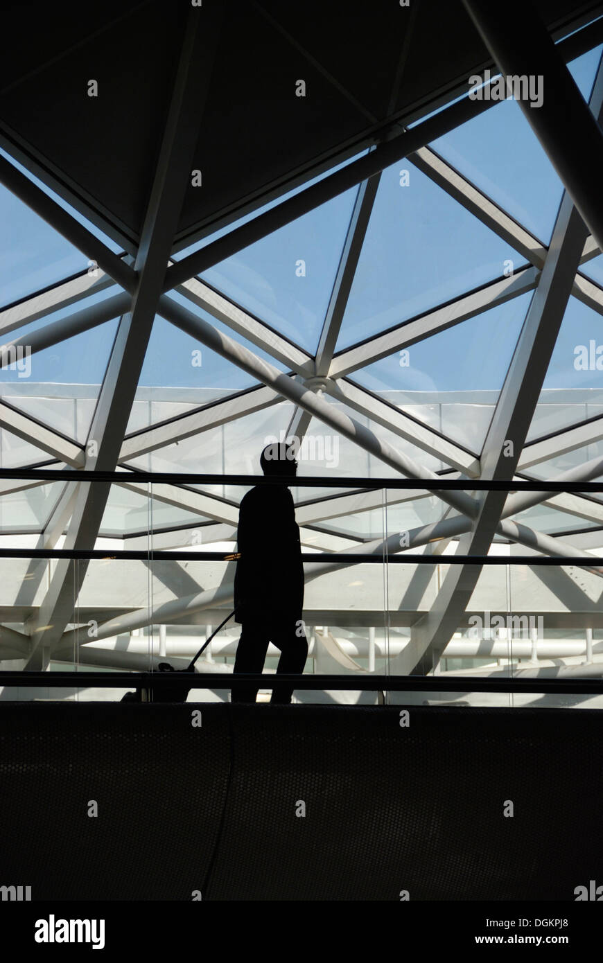 Un uomo cammina attraverso la stazione ferroviaria di King's Cross atrio occidentale. Foto Stock