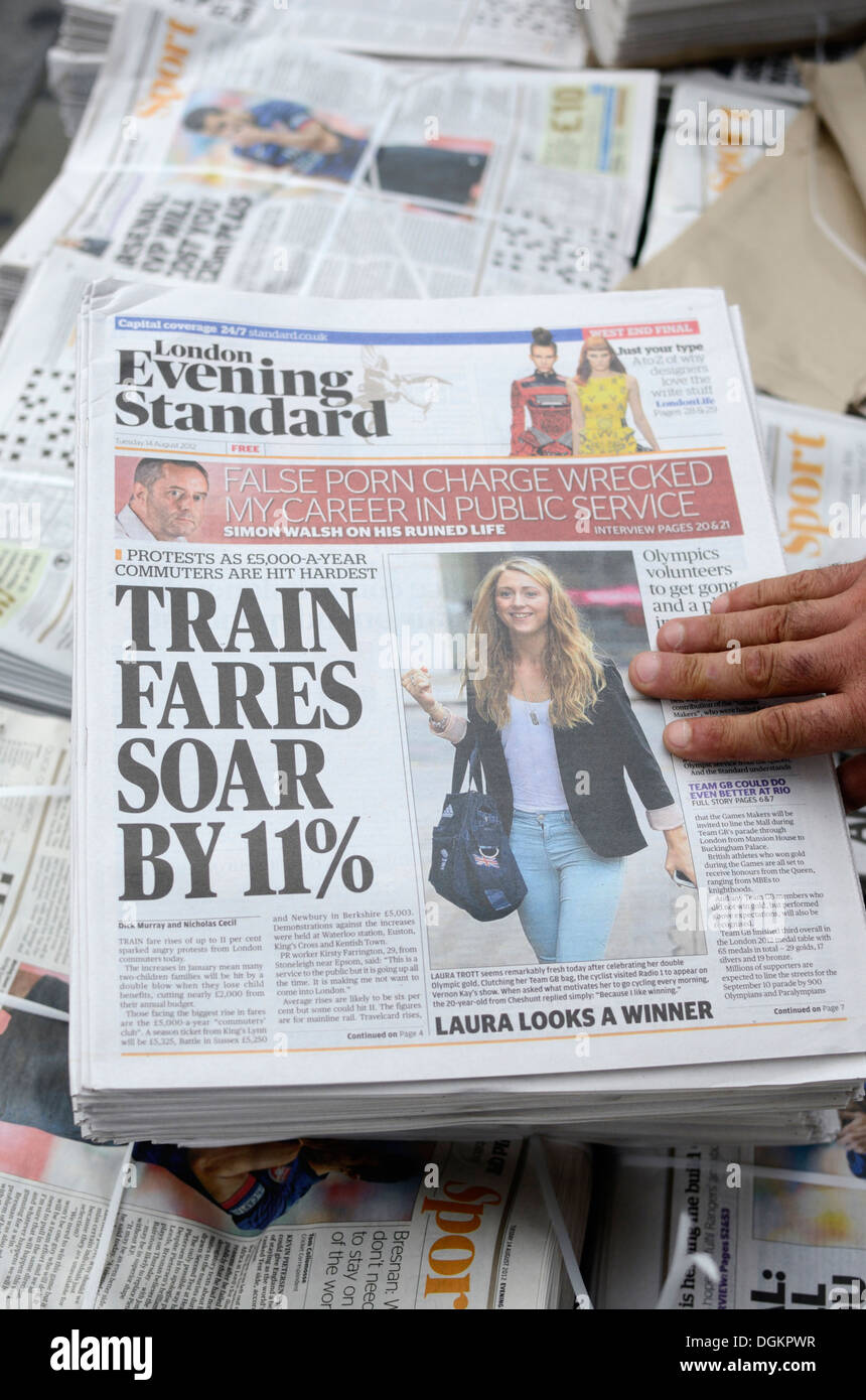 Una mano afferrando una copia del London Evening Standard giornale. Foto Stock