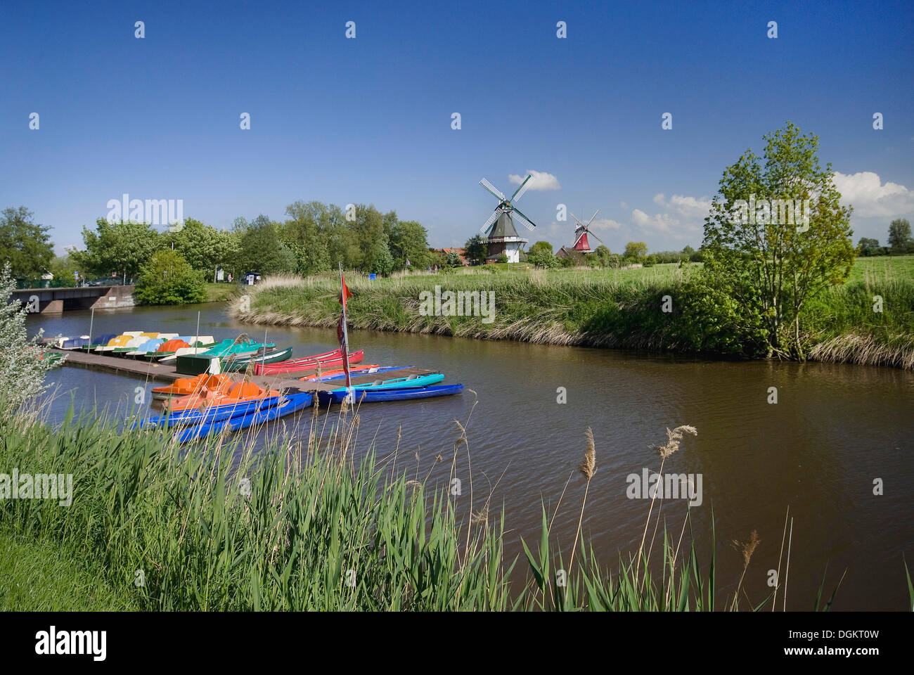 Siel canal con noleggio barche di fronte al twin mulini a vento di Greetsiel, Krummhoern, Frisia orientale, Germania, Europa Foto Stock