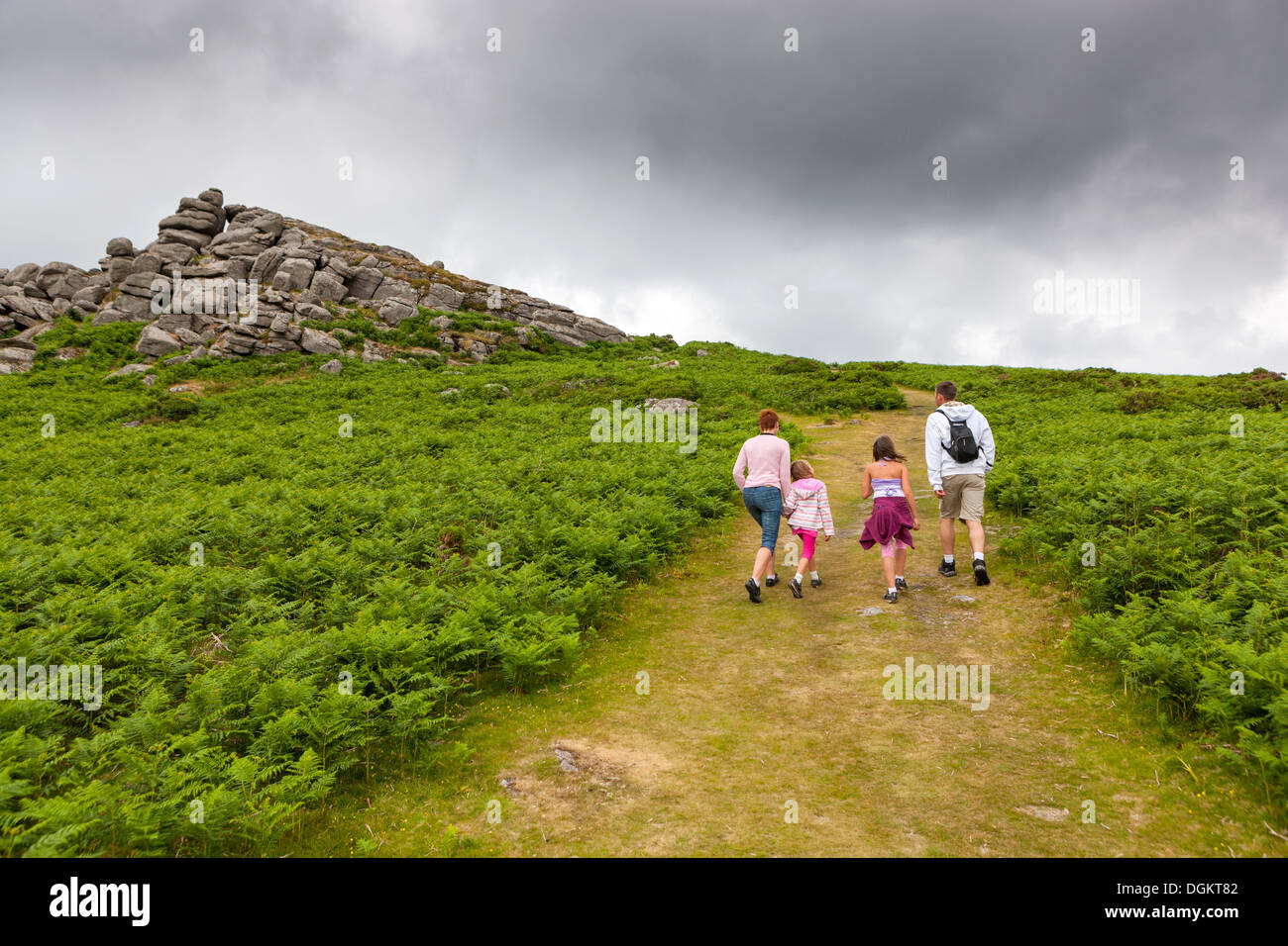 Famiglia salire a piedi a campana Tor nel Parco Nazionale di Dartmoor. Foto Stock