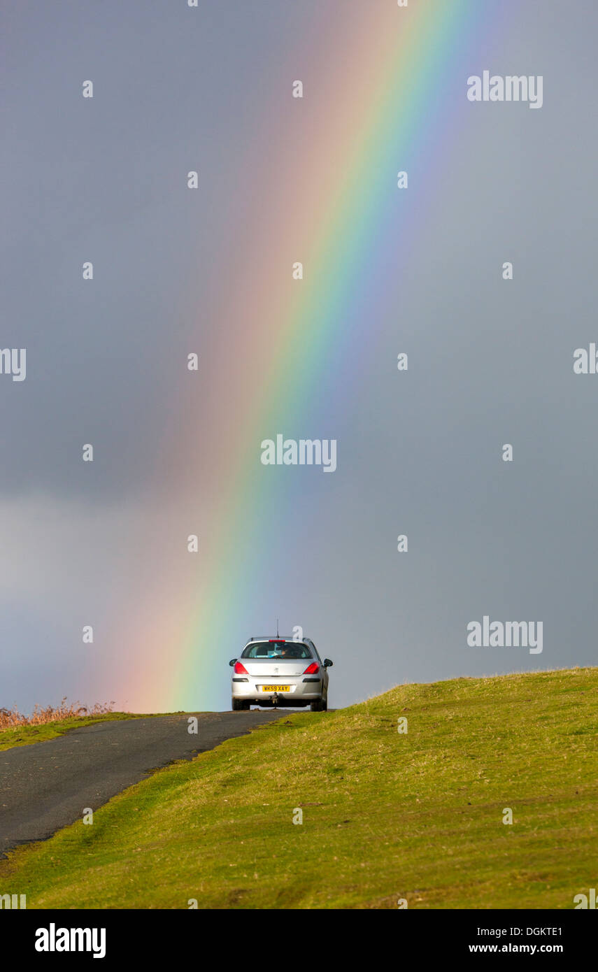 Un arcobaleno su strada vicino a Cox Tor nel Parco Nazionale di Dartmoor. Foto Stock