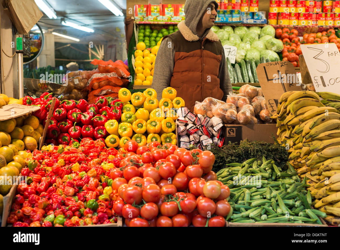 Un fruttivendolo menti un colorato in stallo Brixton Market. Foto Stock