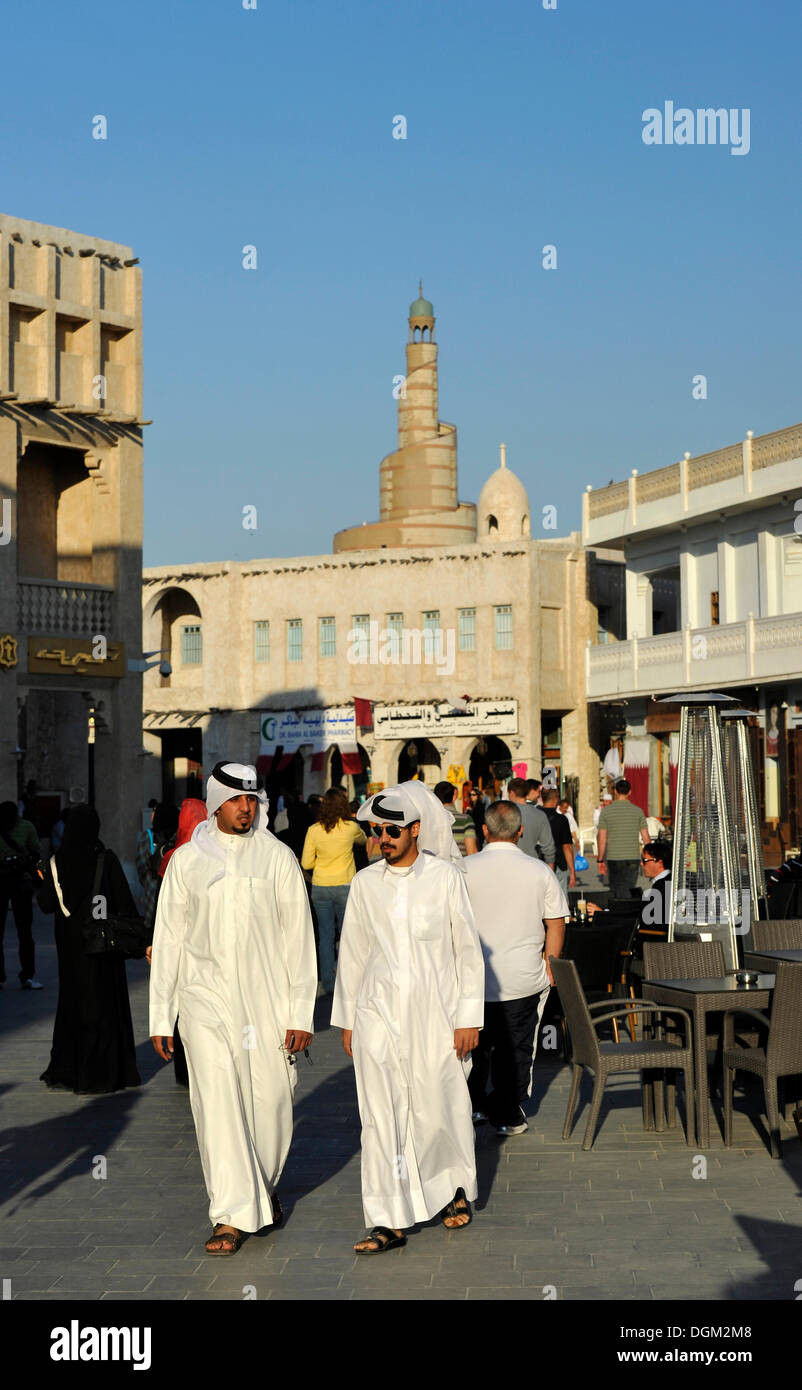 Qatar con ghutrah copricapo passeggiando nei Souq al Waqif, più vecchio souq o bazaar del paese, nel retro della spirale Foto Stock