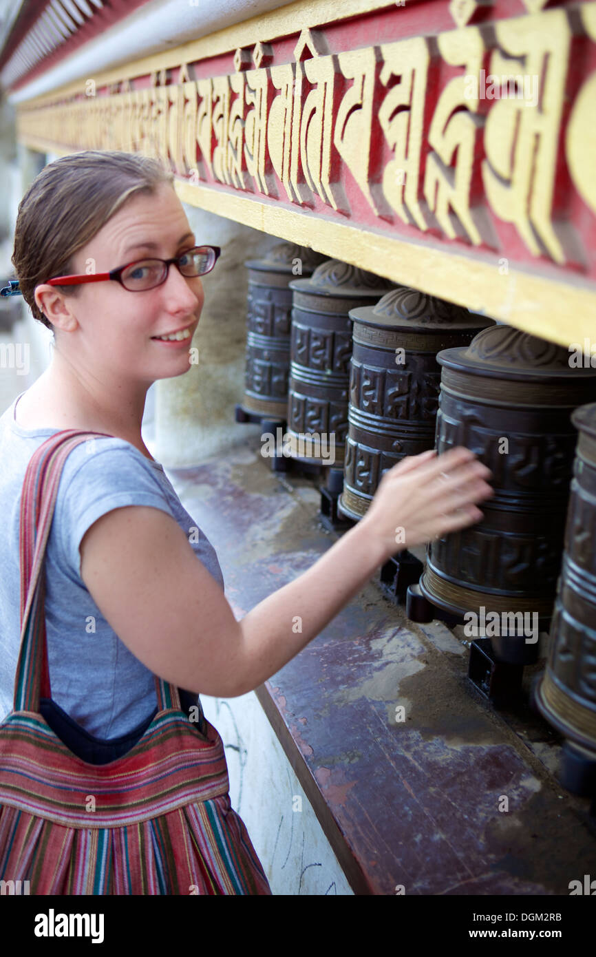 Turismo & ruote della preghiera con mantra Chenrezig, Swayambhu, Swayambhunath (tempio delle scimmie), Kathmandu, Nepal, Asia Foto Stock