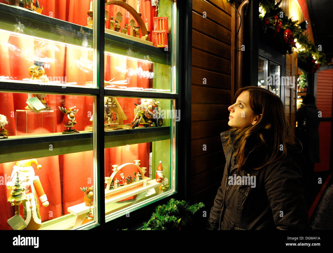 Giovane donna guardando giocattoli dai Monti Metalliferi in una finestra di visualizzazione, mercatino di Natale di Stoccarda, Baden-Wuerttemberg Foto Stock