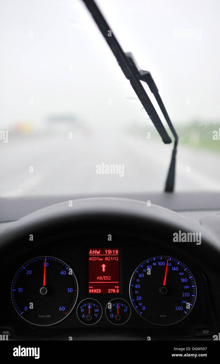 La scarsa visibilità in caso di pioggia, autostrada, illuminato il tachimetro con display di navigazione, guida VW Golf Foto Stock