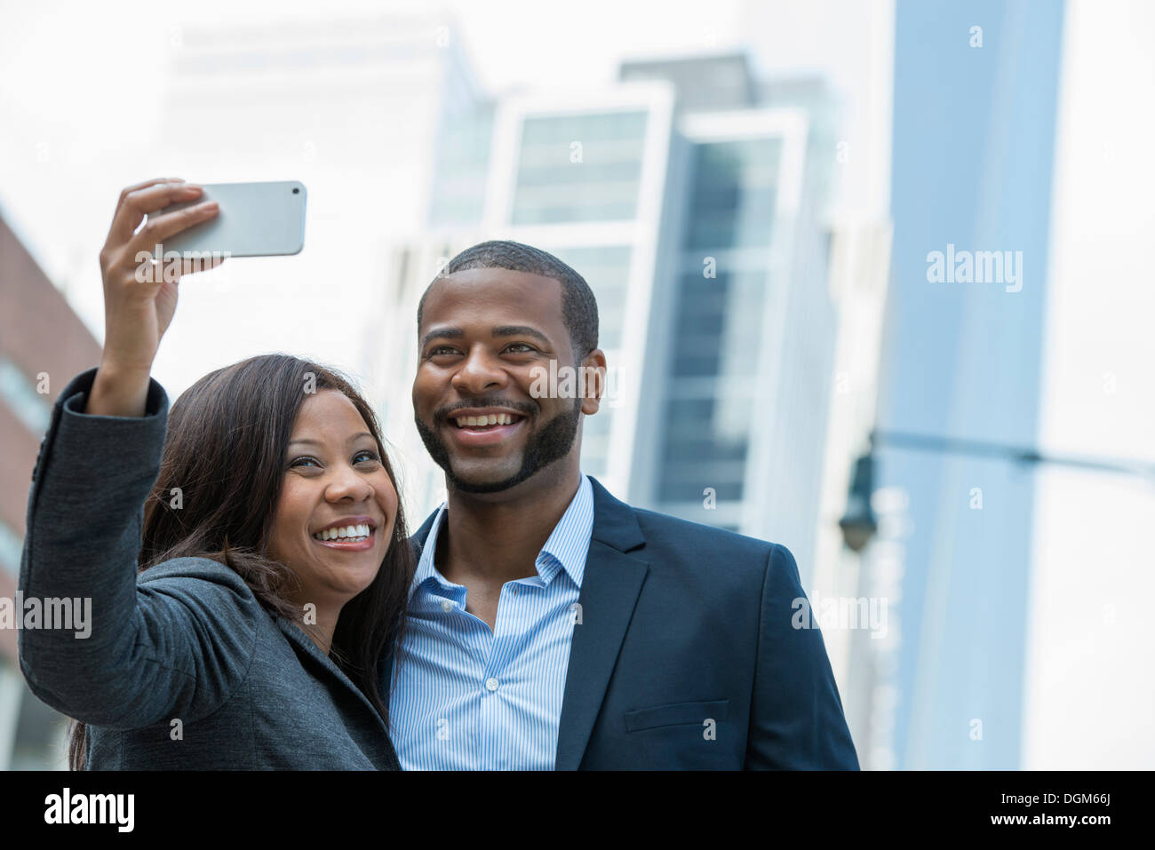 L'estate. Un paio di prendere una selfy, una donna tenendo fuori uno smart phone e prendendo le loro foto. Foto Stock