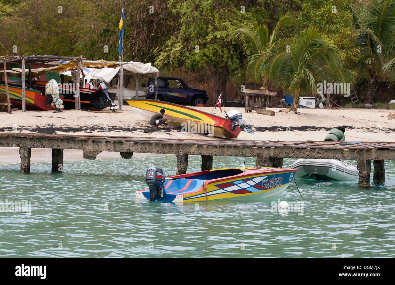Salt Whistle Bay, Jetty, taxi d'acqua, barca e gli uomini sulla spiaggia, con alberi e Storage, Mayreau, Tobago Cays, parco marino: Sai Foto Stock