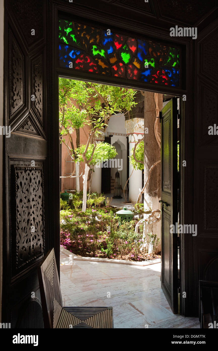 Le vetrate colorate e ornate portale scolpito sul riad marocchino Foto Stock