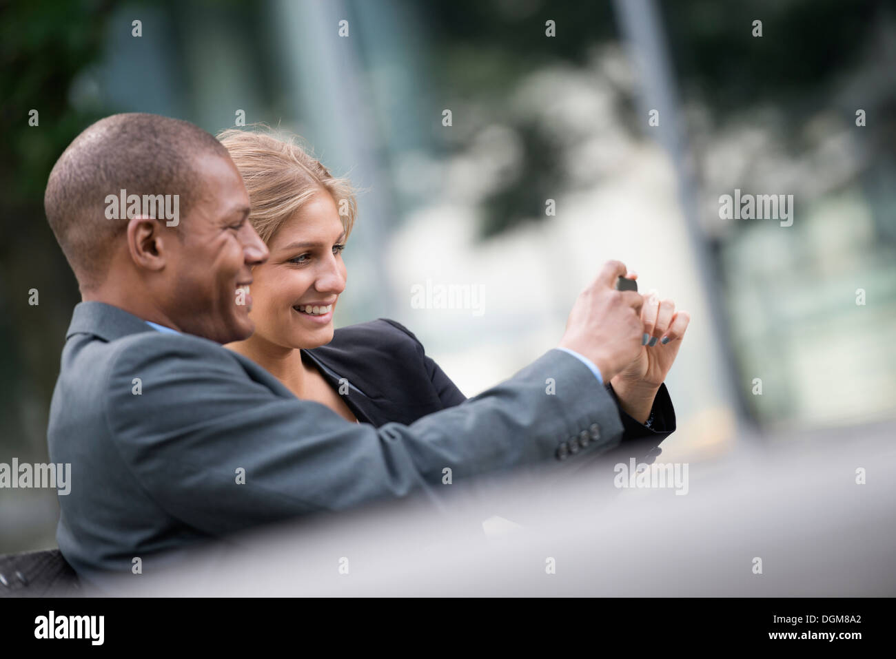 Una giovane donna bionda uomo sulla città di New York Street indossare vestiti business in piedi a fianco a fianco tenendo selfy fotografia smart Foto Stock