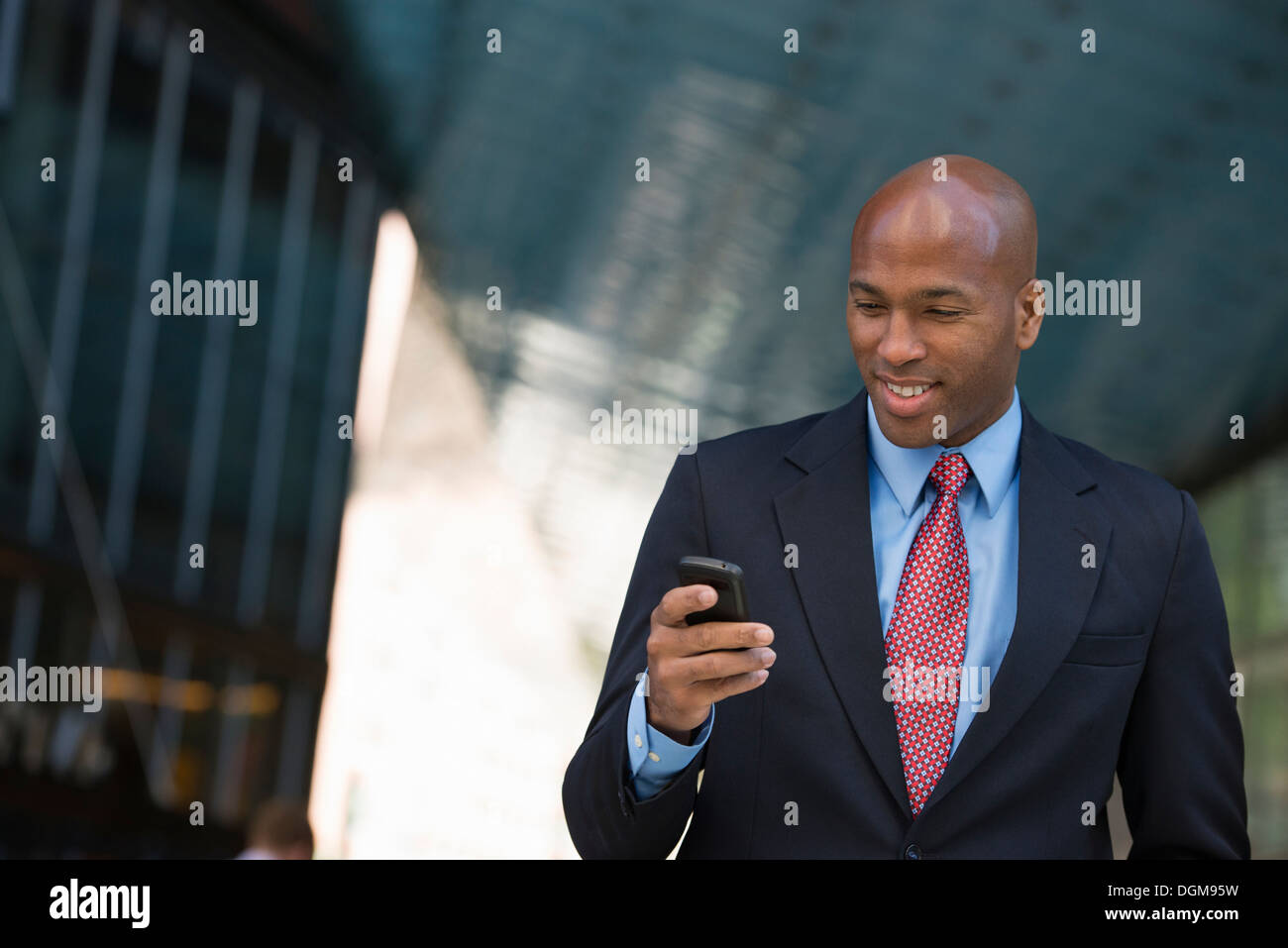 La gente di affari. Un uomo in una tuta controllando il suo telefono. Foto Stock