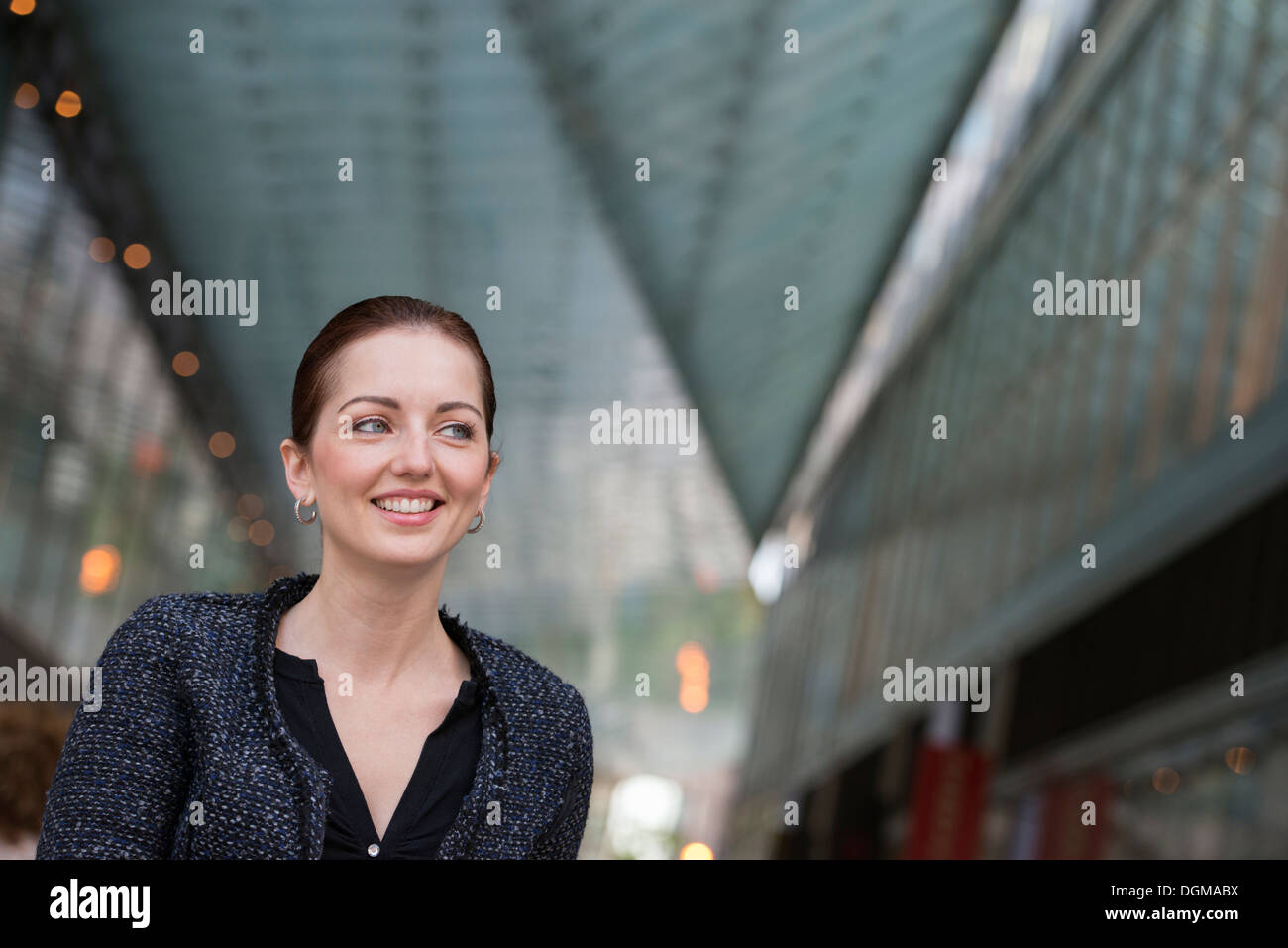 La gente di affari esterni. Una donna in una giacca grigia con i suoi capelli fino, sorridente. Foto Stock