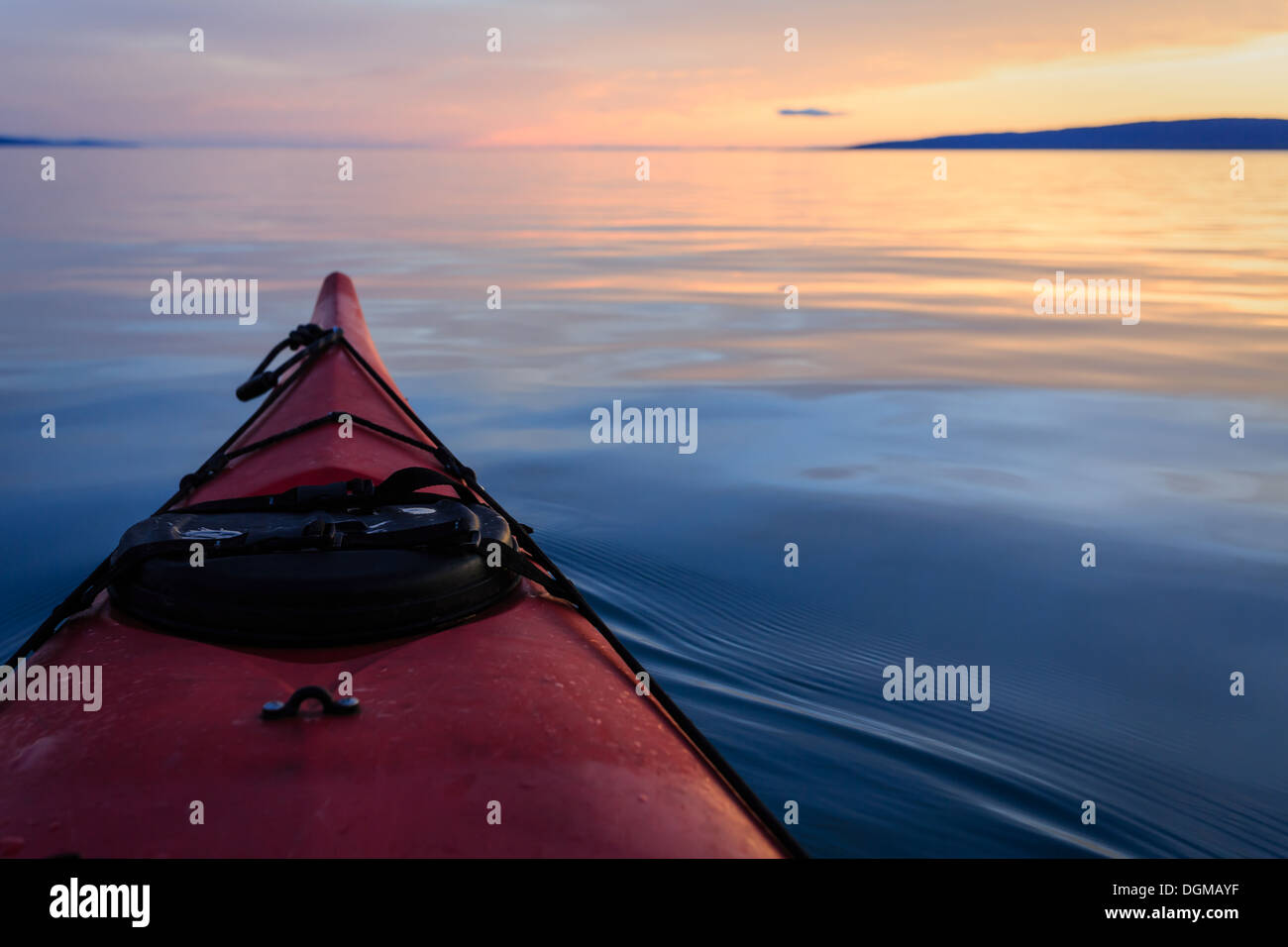 Costeggia il kayak su calme acque cristalline e lisce al tramonto con riflessi colorati del cielo sull'acqua Foto Stock Costeggia il kayak su calme acque cristalline e lisce al tramonto con riflessi colorati del cielo sull'acqua Foto Stock