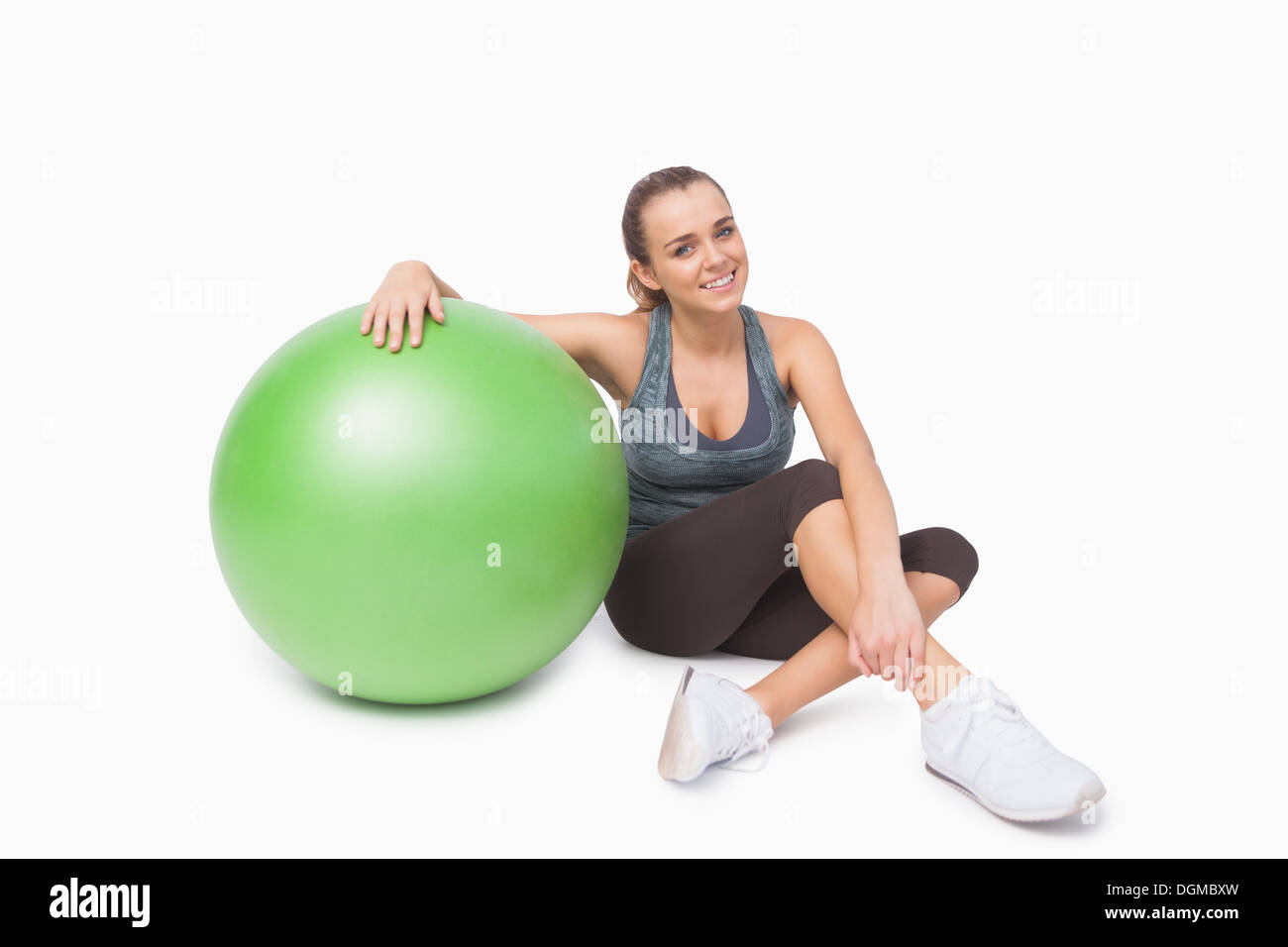 Carino donna seduta accanto a una sfera di fitness Foto Stock