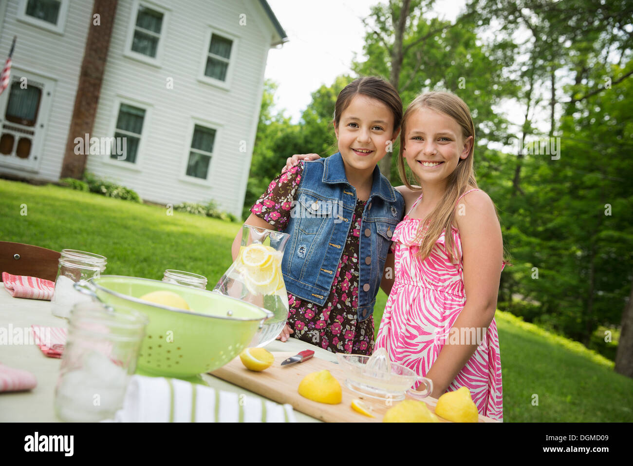 Un estate incontro di famiglia in una fattoria. Due bambini in piedi a fianco a fianco. Rendendo la limonata fatta in casa. Foto Stock