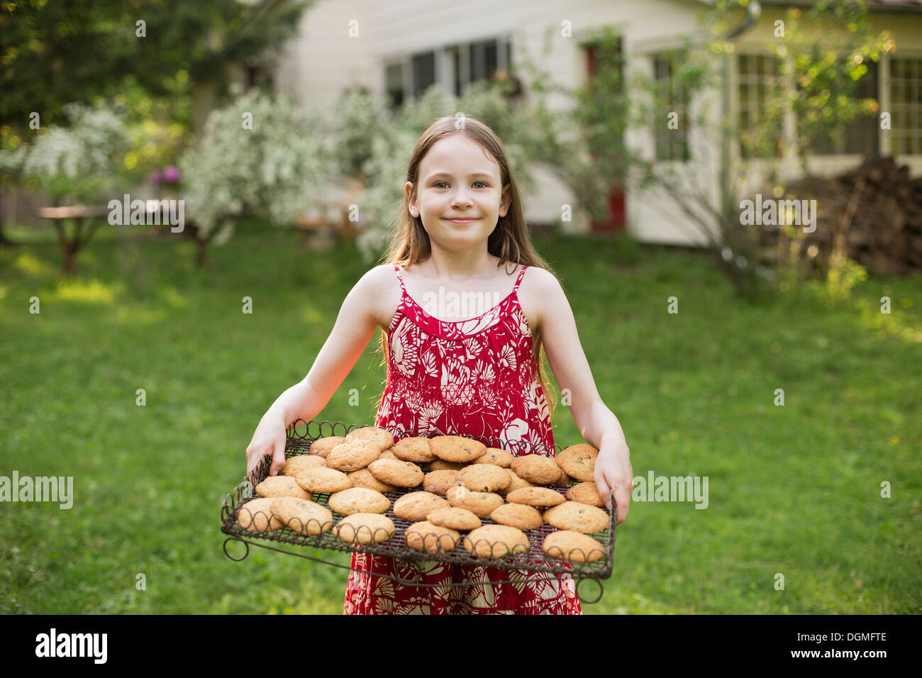 La cottura biscotti fatti in casa. Una giovane ragazza con un vassoio di biscotti appena sfornati. Foto Stock