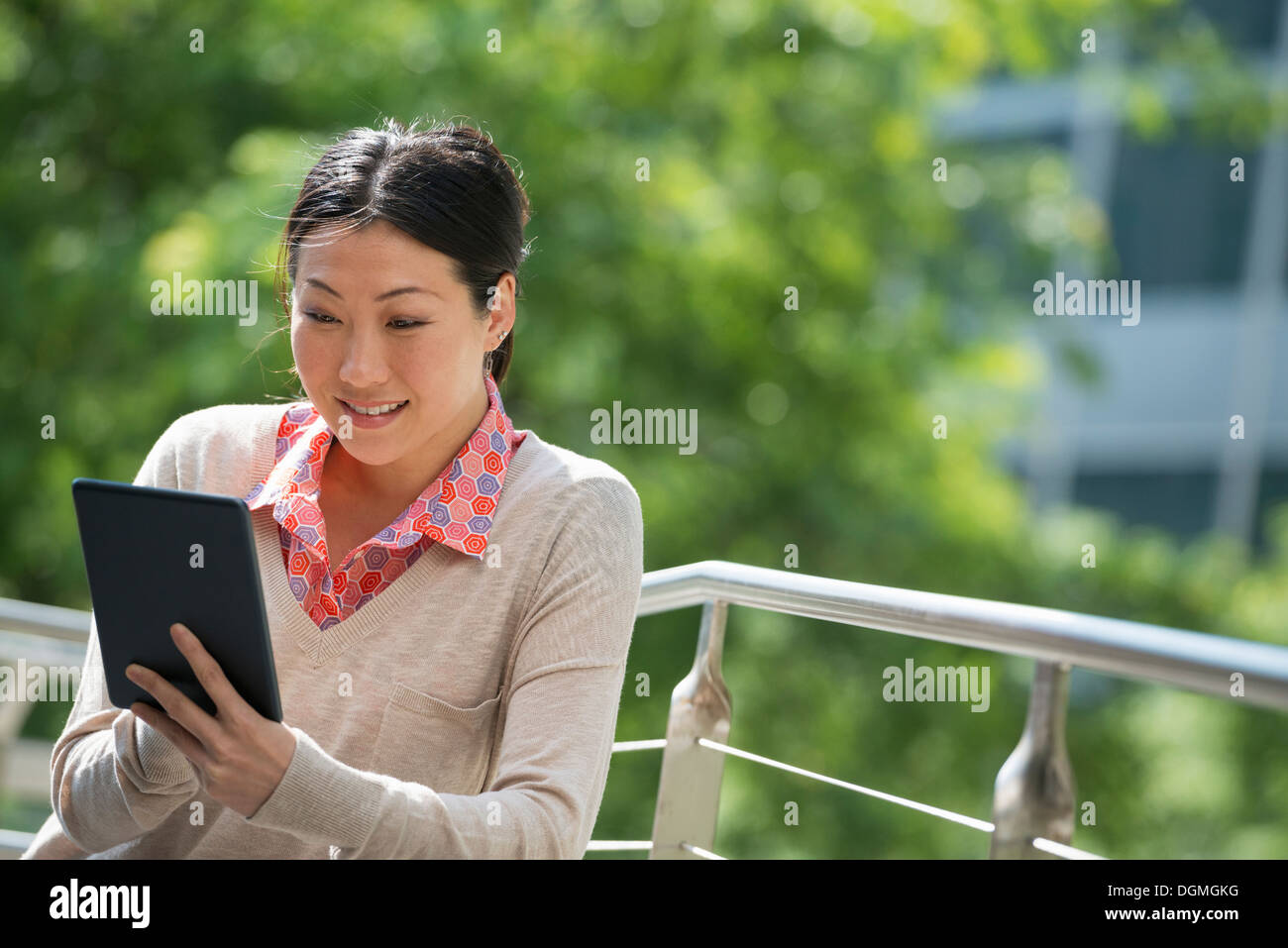 L'estate. La gente di affari. Una donna con una tavoletta digitale, lavorando. Tenersi in contatto. Foto Stock