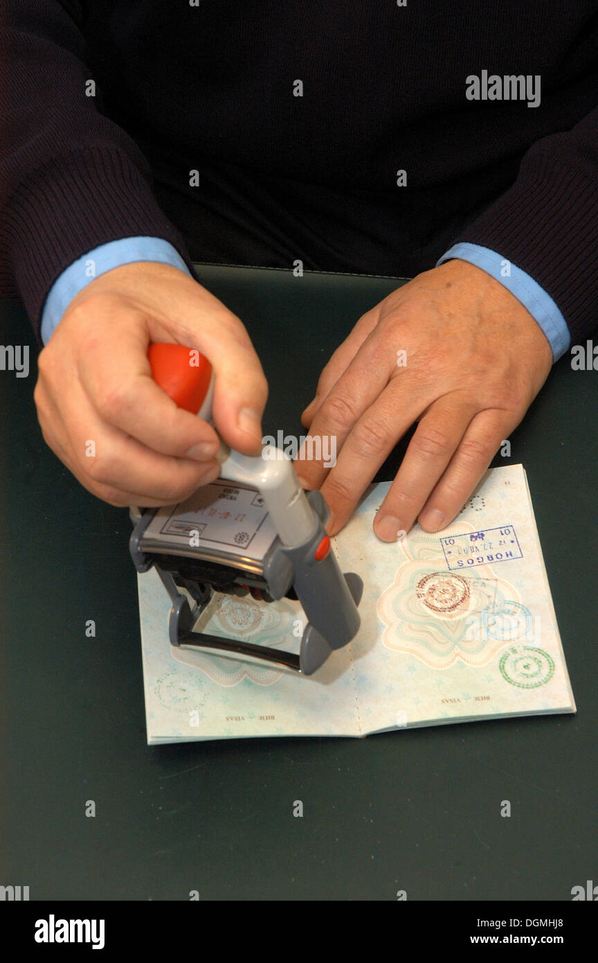Le mani con un timbro in un controllo passaporti Foto Stock