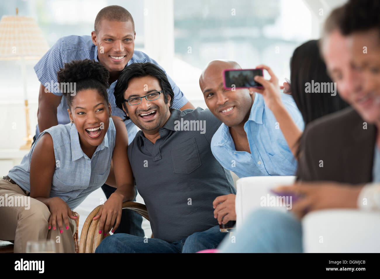 Evento di office. Un uomo prendendo un selfie del gruppo con uno smart phone. Foto Stock