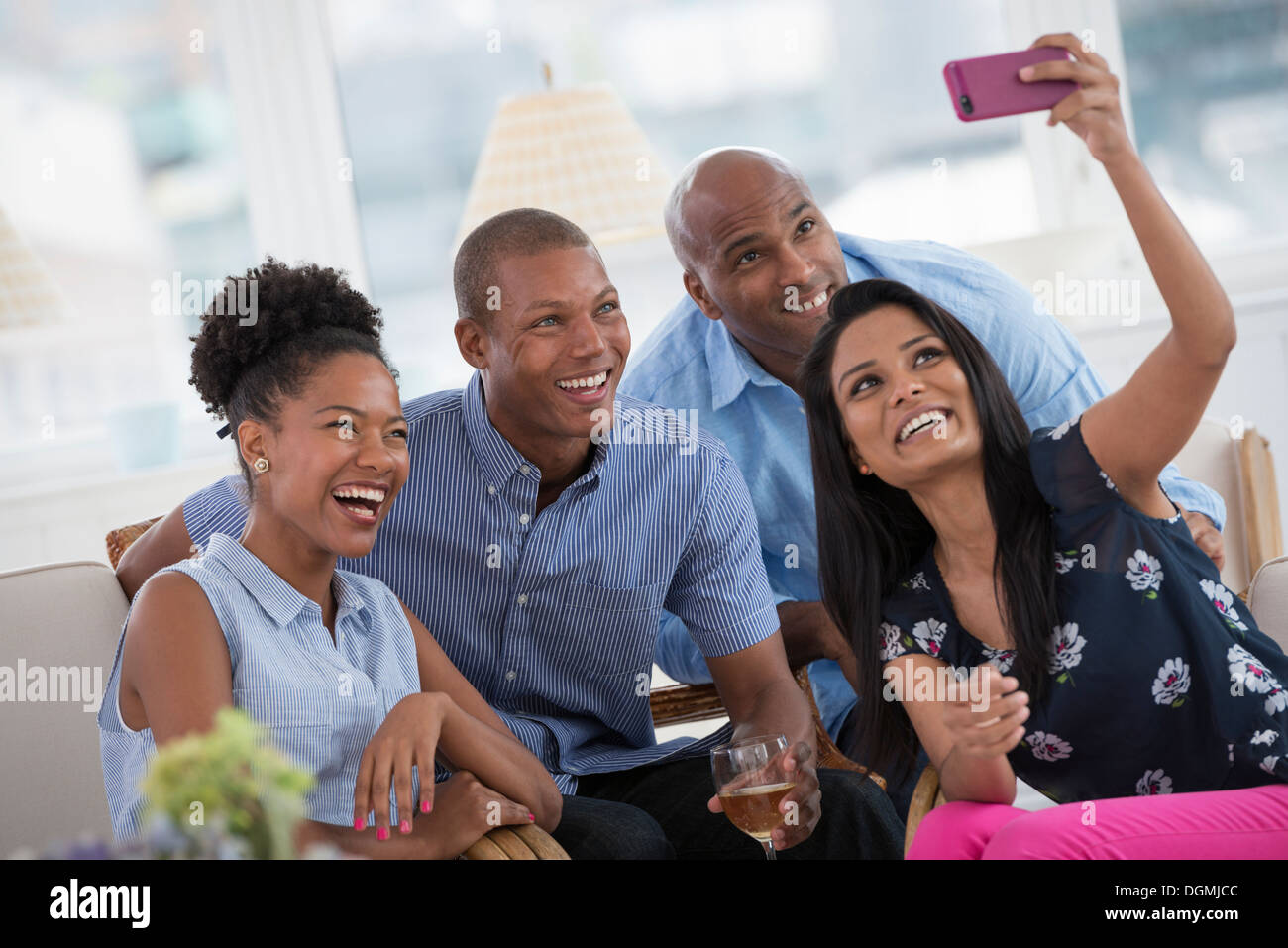 Evento di Office. Una donna prendendo un selfie del gruppo con una rosa di smart phone. Foto Stock