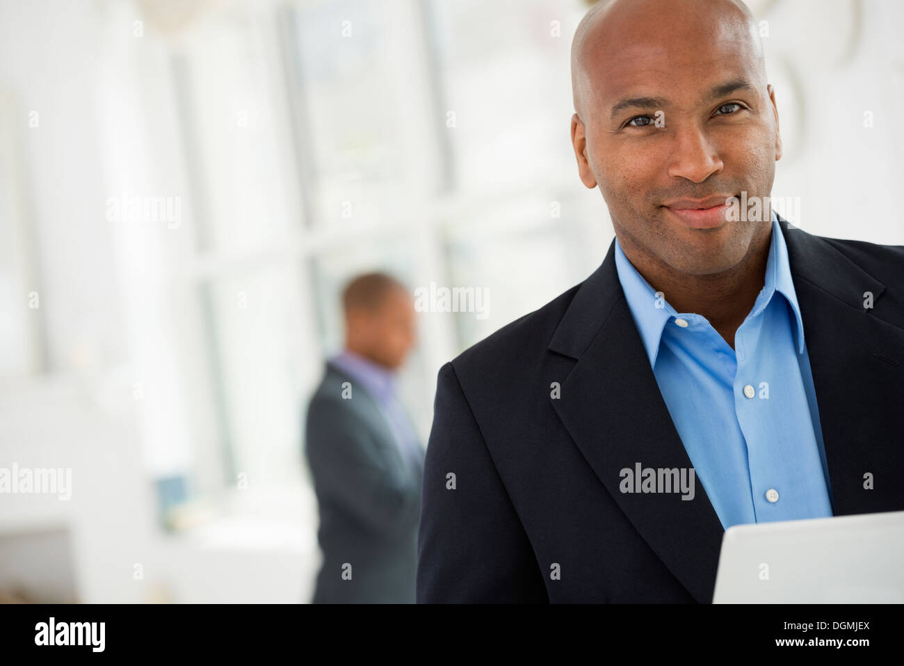 La gente di affari. Un uomo in un business suit utilizzando una tavoletta digitale. Foto Stock