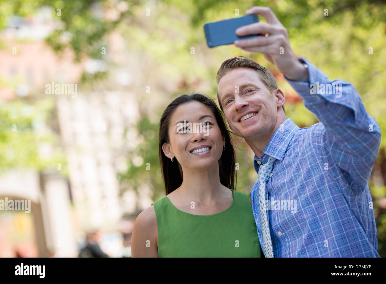 Una coppia di uomo e donna prendendo un selfy con uno smart phone. Foto Stock