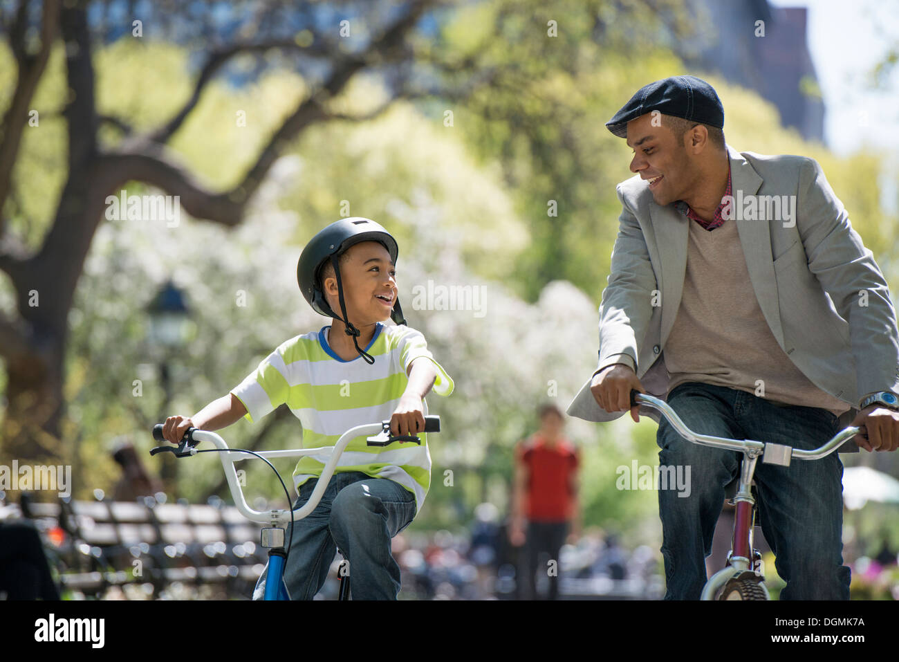 Ciclismo e divertirsi. Un padre e figlio fianco a fianco. Foto Stock