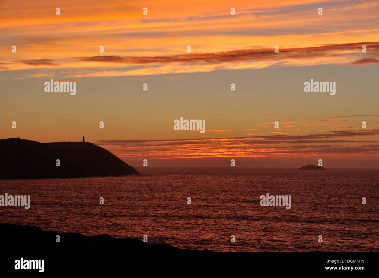 North Cornwall - tramonto sulla silhouette Stepper Point - rosso arancio e blu cloudscape oltre mare cremisi - twilight Foto Stock