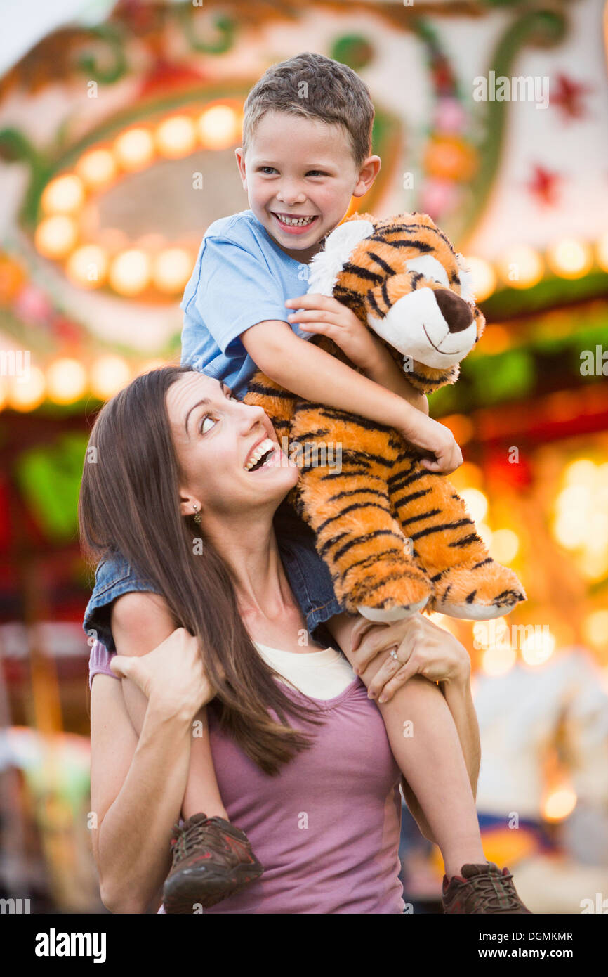 Stati Uniti d'America, Utah, Salt Lake City, Madre dando il suo figlio (4-5) piggyback ride nel parco di divertimenti Foto Stock