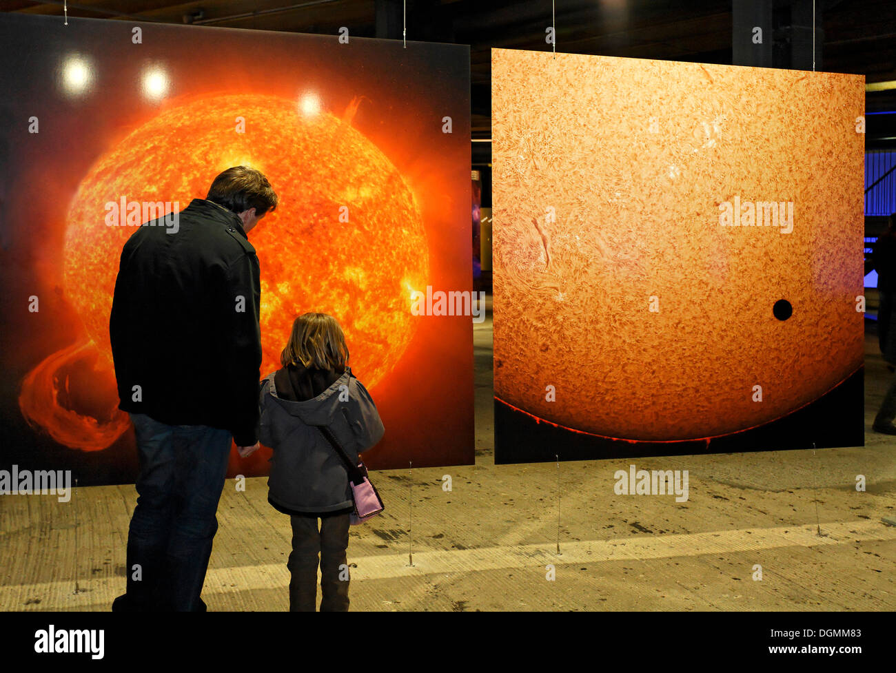 Padre explaing una grande foto del rosso-sole caldo al suo giovane figlia, exhibition Wunder des Sonnensystems Foto Stock