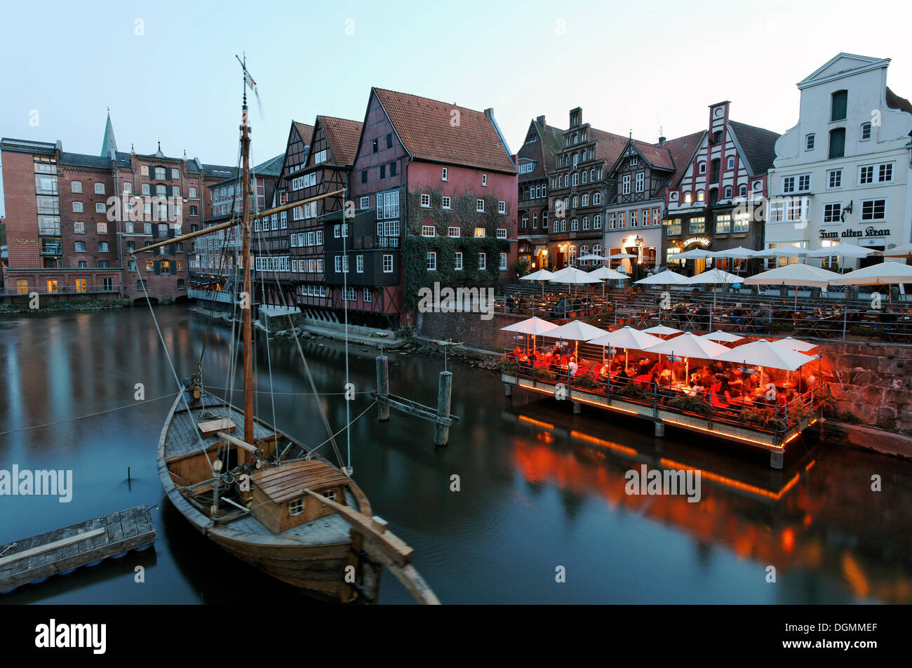 Sale storiche porta sul fiume Ilmenau, atmosfera serale, pub su Stintmarkt, illuminato ristorante Le Terrazze, Lueneburg Foto Stock