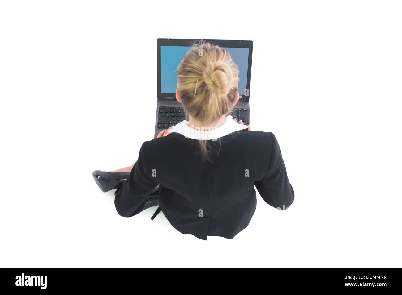 Giovane imprenditrice pacifica a lavorare con il suo computer portatile seduto sul pavimento Foto Stock