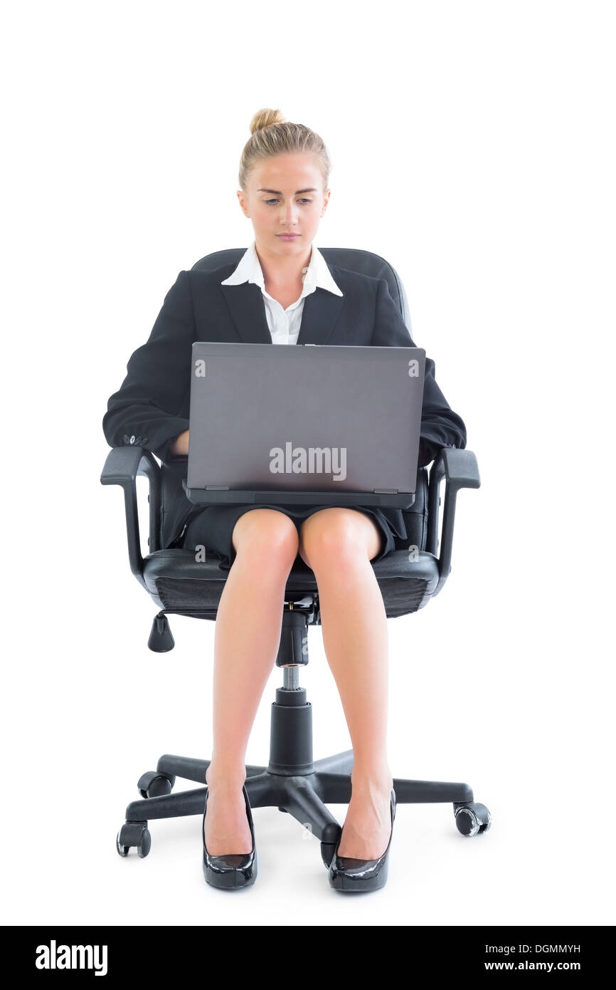 Bella imprenditrice seduto su una sedia per ufficio utilizzando il notebook Foto Stock