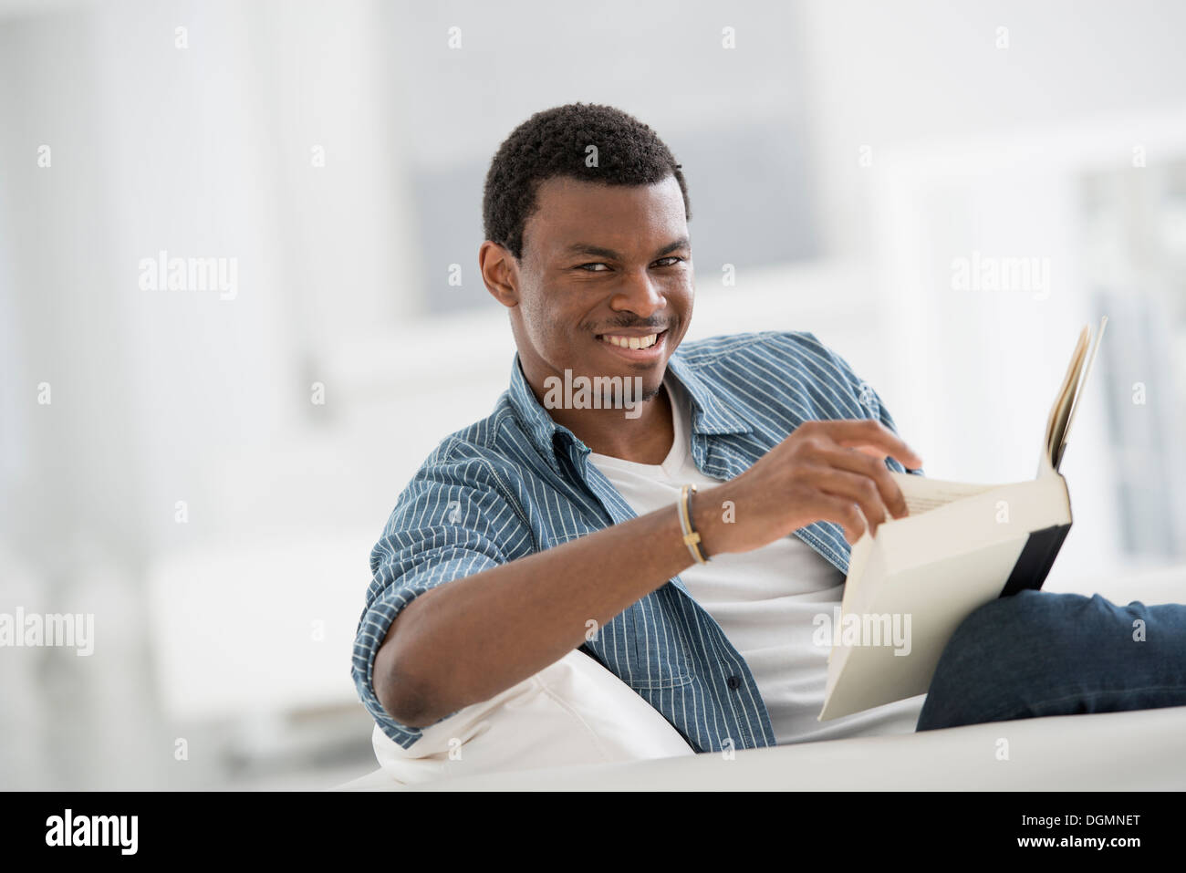 Un bianco luminoso con sala interna. Un uomo seduto a leggere un libro. Foto Stock