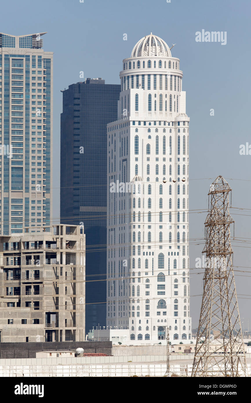 I grattacieli e a Sospesa la costruzione del sito con l'involucro edilizio, Jumeirah Lake Towers, Dubai, Emirati Arabi Uniti Foto Stock