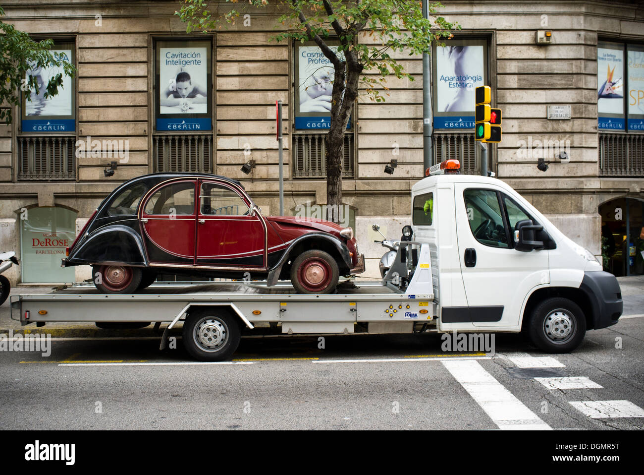 Citroën 2CV su un carrello di traino nelle strade di Barcellona. Foto Stock