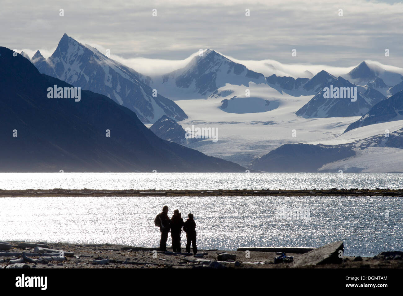 Sagome dei partecipanti alla spedizione di fronte alla montagna e panorama sul ghiacciaio di Smeerenburgbreen, Smeerenburgfjorden Foto Stock