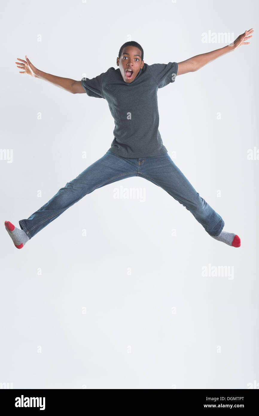 Studio shot del ragazzo adolescente (14-15) jumping Foto Stock