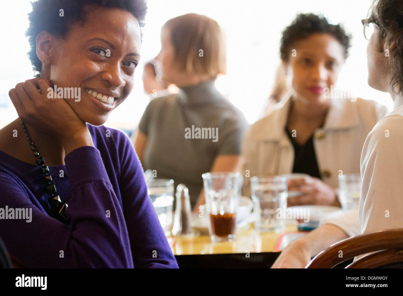 La vita della città. Un gruppo di persone in un café, controllando la loro smart phone. Foto Stock