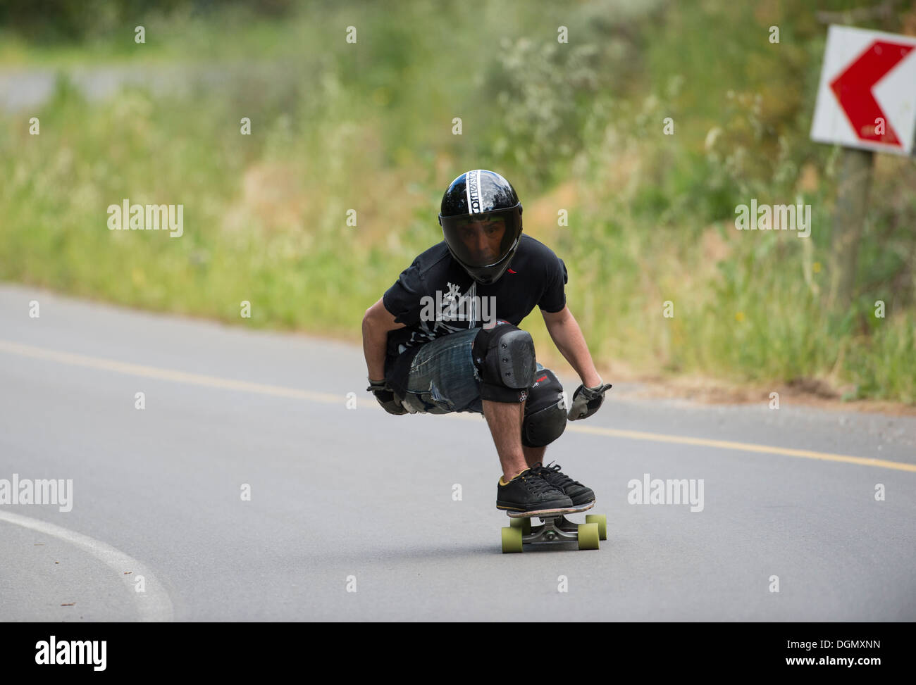 Skateboard longboard giovane formazione in discesa su strada pubblica Foto Stock