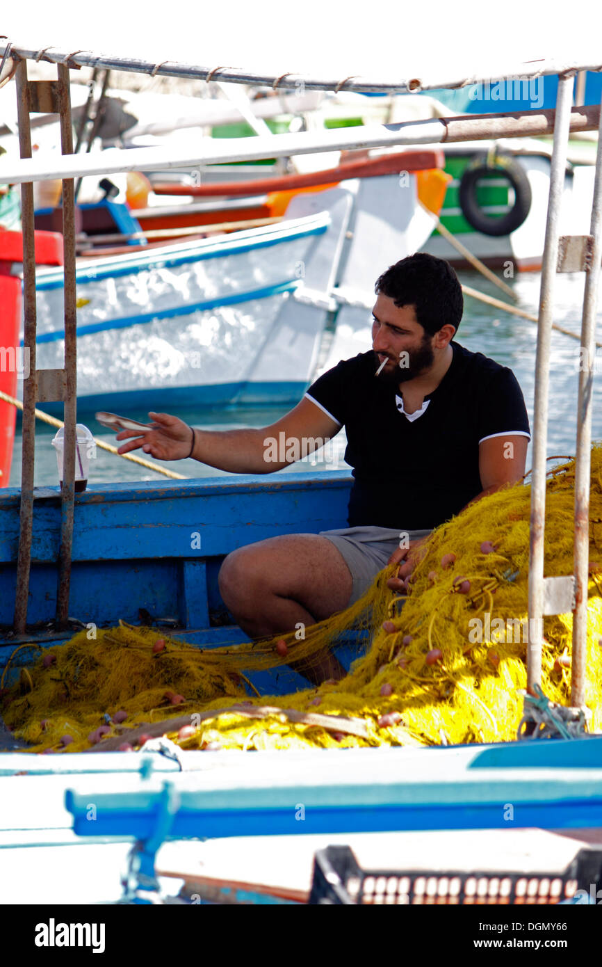 Pescatore greco ordinamento la sua cattura. ELOUNDA CRETE. Foto Stock
