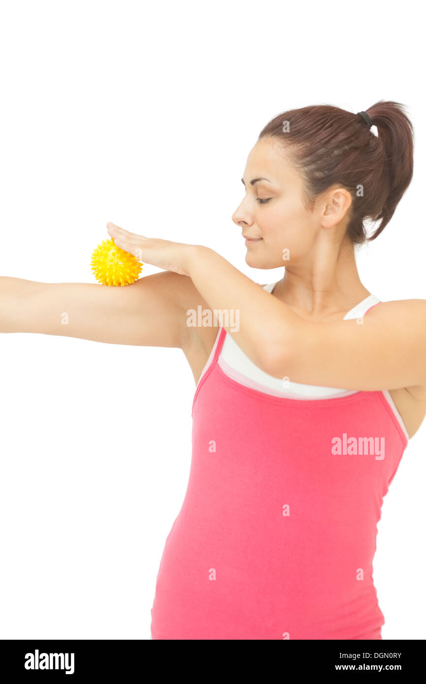 Contenuto bruna sportivo di toccare il braccio con il giallo sfera di massaggio Foto Stock