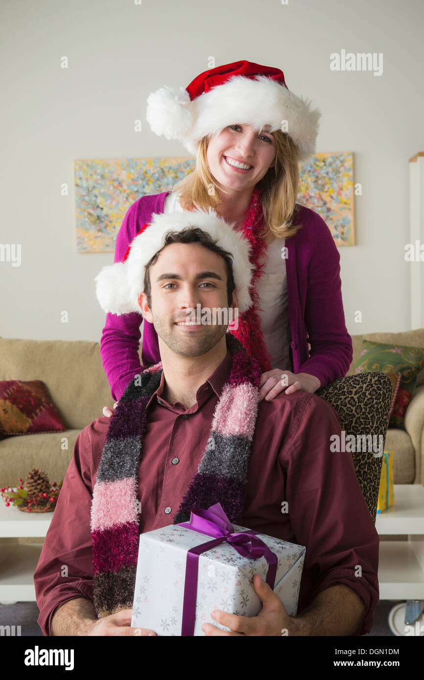 Ritratto di coppia giovane indossando cappelli di Babbo Natale Foto Stock