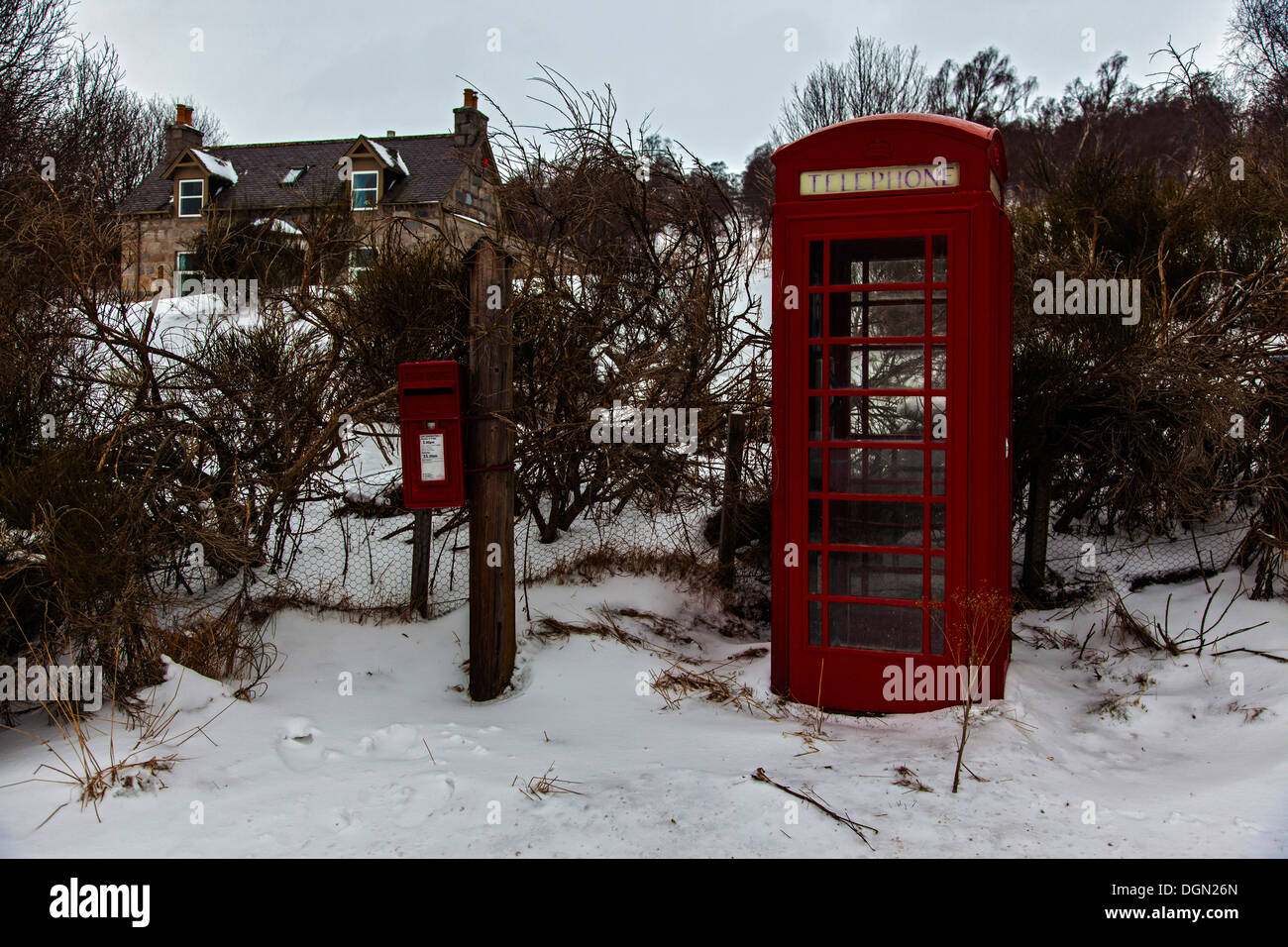 Coperte di neve e di terra rosso classico phone booth e piccolo red letter box sulla vecchia strada militare vicino a Balmoral in Aberdeenshire Foto Stock