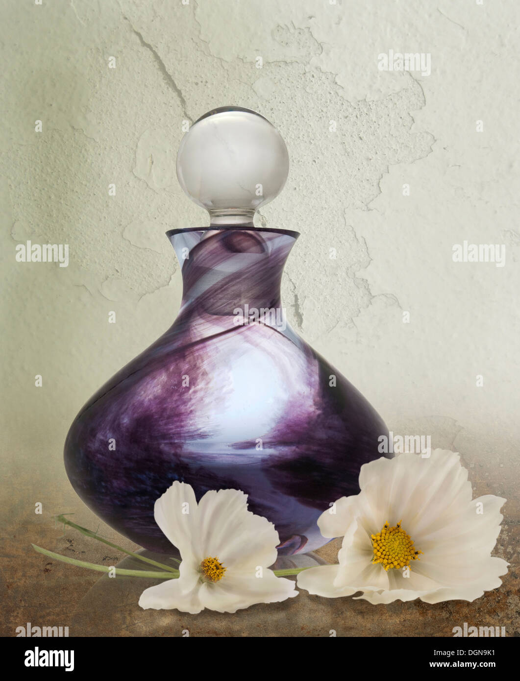 Una immagine composita di un cristallo bottiglia di profumo di fiori bianchi. Foto Stock