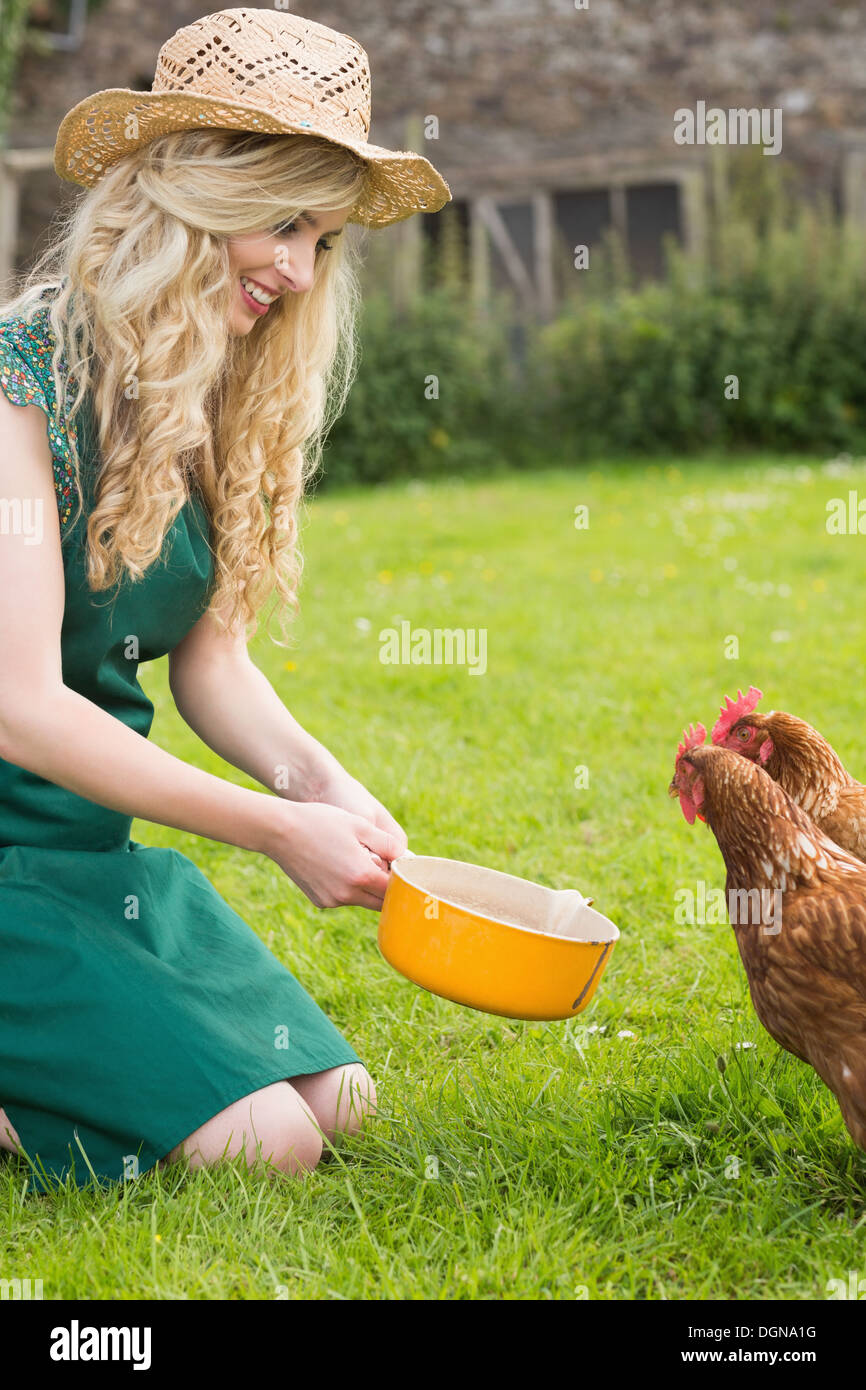 Giovane donna alimentando il suo pollo Foto Stock