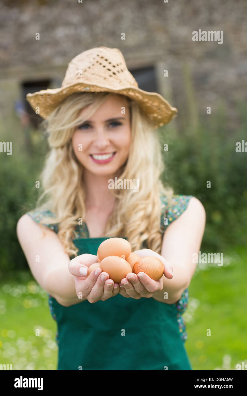 Giovane donna bionda che mostra le uova Foto Stock